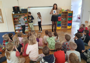 Nauczycielka pezentuje dzieciom ilustrację.