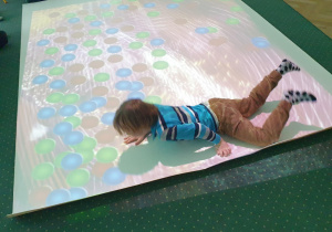 Chłopiec leży na podłodze interaktywnej.