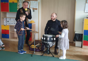 Dziewczynka i chłopiec grają na instrumentach perkusyjnych.