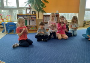 Dzieci uczestniczą w zabawach paluszkowych.