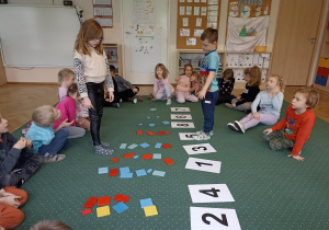 Dzieci dopasowują znaki graficzne liczb do konkretów.