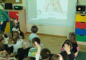 Dzieci biorą udział w zajęciach z tablicą interaktywną.