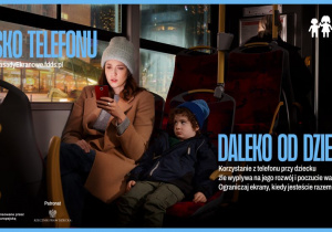 Mama siedząca z dzieckiem w autobusie, patrząca na swój telefon.