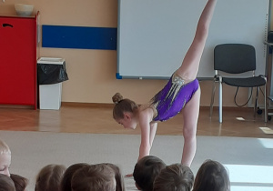 Dzieci obserwują pokaz gimnastyki artystycznej.