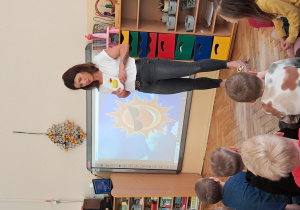 Nauczycielka pokazuje dzieciom obrazek.