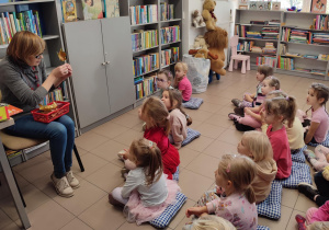 dzieci siedzą w bibliotece