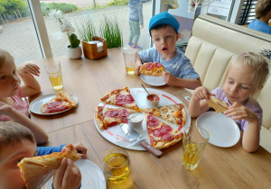 Dzieci jedzą pizzę