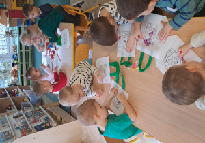 Dzieci siedzą przy stolikach