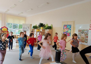 Dzieci chwytają się pod boki i tańczą
