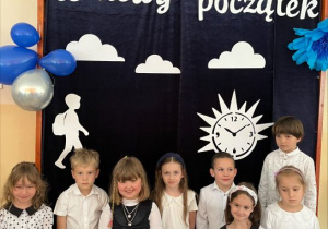 Dzieci stoją zdyplomami ukończenia przedszkola