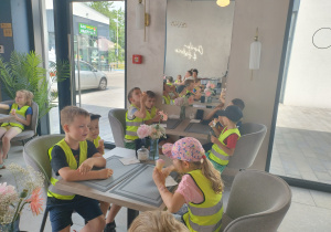 Dzieci jedzą lody w kawiarni