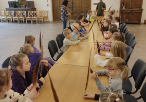 dzieci trzymają długie piórka