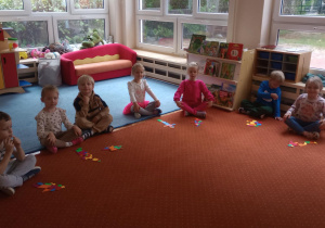 Dzieci siedzą na dywanie