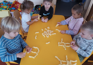 Dzieci siedzą przy stolikach