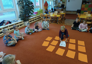 Dzieci siedzą na dywanie
