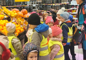 Dzieci oglądają stoiska z owocami