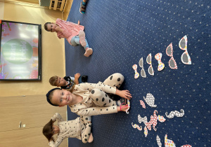 Dziewczynka układa elementy zawierające kropki w odpowiednim rytmie