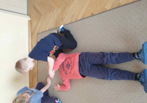 Dziewczynka uczy kolegę pozycji bezpiecznej