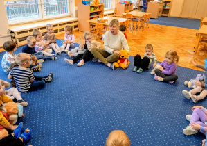 Dzieci siedzą w kole z misiami