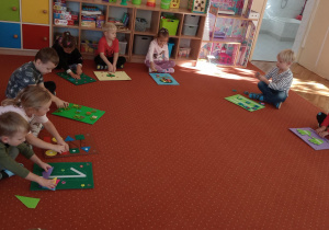 Dzieci siedzą na dywanie