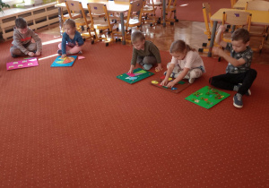 Dzieci siedzą na dywanie