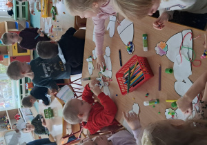 Dzieci siedzą przy stolikach