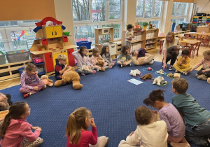 Dzieci biorą udział w zajęciach na dywanie