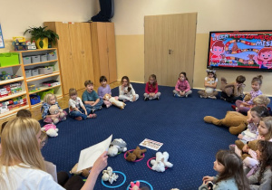 Dzieci siedzą na dywanie