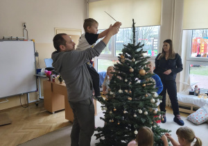 Chłopiec z tatą wieszają gwiazdę