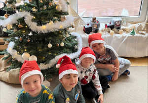 Chłopcy siedzą pod choinką