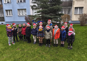 Grupa stoi przed choinką