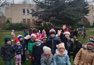 Dzieci pozują do zdjęcia przy osiedlowej choince
