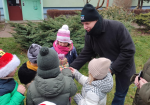 Pan rozdaje dzieciom prezenty.