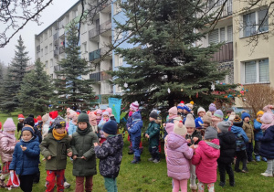 Dzieci stoją na trawie.