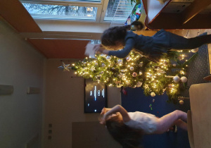 Dziewczynki skaczą przy choince.