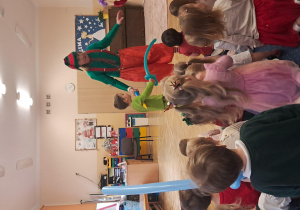 Dzieci na scenie trzymają miecze wykonane z balonów.