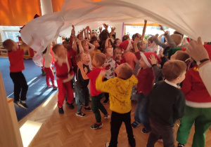 Dzieci stoją pod białą folią.