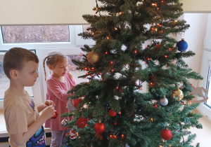 dzieci ubierają choinkę
