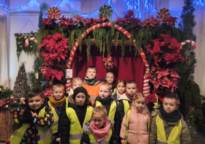Grupa pozuje na tle dekoracji świątecznych