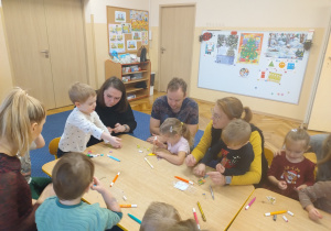 Grupa przy stoliku ozdabia choinki