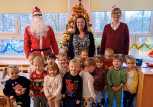 Grupa stoi przed choinką z Mikołajem