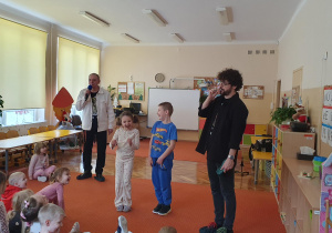 Chłopiec z dziewczynką stoją roześmiani na scenie