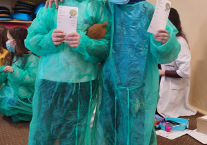 Dwóch chłopców w fartuchach lekarskich.