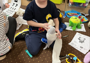 Chłopiec bandażuje przytulankę