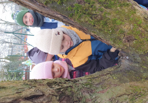 Dzieci stoją przy drzewie