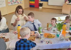 Babcie i dziadkowie przy stole z wnukami