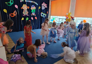 Dzieci w przebraniach, w tle karnawałowa dekoracja