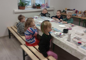 Dzieci siedzą przy stołach