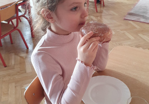 dziewczynka je pączka