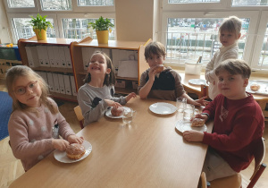 dzieci jedzą pączki